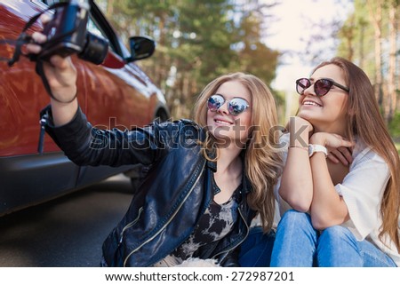 Happy friends on road trip taking selfie on a summers day. Little holiday trip