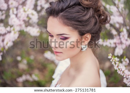 Portrait of brunette bride over blossom tree