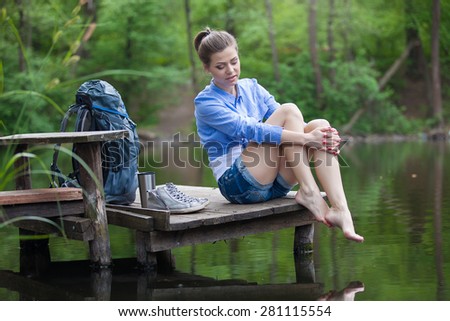 Active healthy woman hiking in beautiful forest. Portrait of happy smiling young woman resting on lake.
