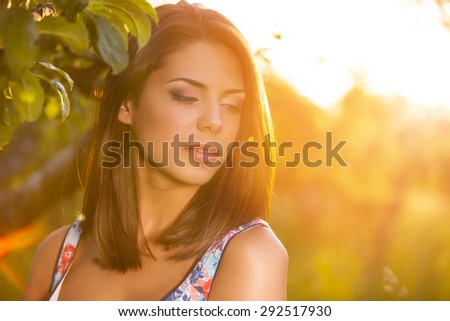 Beauty Girl Outdoors enjoying nature. Sun Light. Glow Sun. Free Happy Woman. Toned in warm colors
