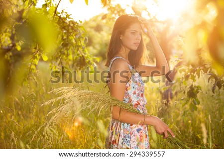 Beauty Girl Outdoors enjoying nature. Sun Light. Glow Sun. Free Happy Woman. Toned in warm colors