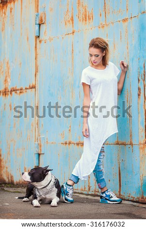 modern punk fashion, portrait of a beautiful model posing on the street with dog.  Modern Youth Lifestyle Concept