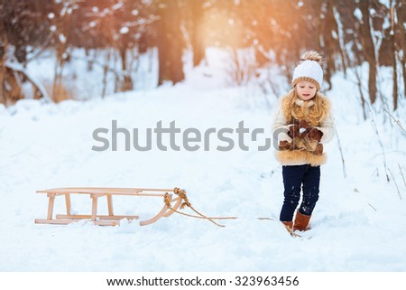 Little girl enjoying a day out playing in the winter forest
