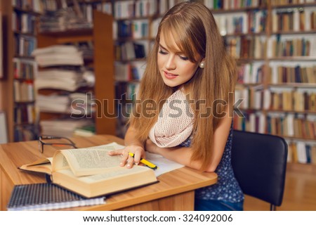 Portrait of a young female student standing in a university library