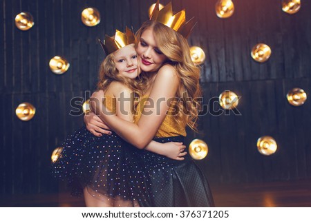 Beautiful princess mother and daughter in a gold crown