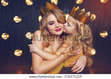 Beautiful princess mother and daughter in a gold crown