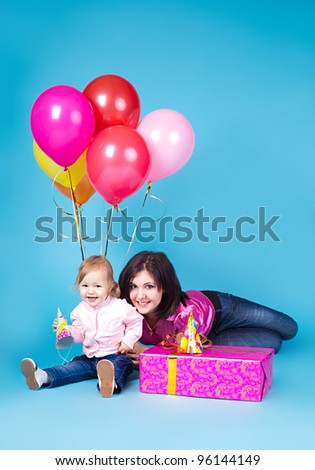 The family, mother and child celebrate with a gift and balloons