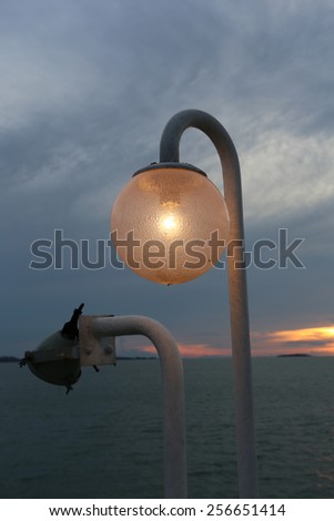 The lantern on the ferry on the background of blue sky and sunset