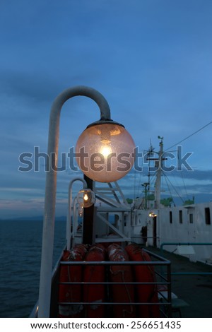 The lantern on the ferry on the background of blue sky and sunset