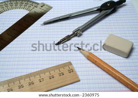 Compasses, pencil, eraser and rulers on squared paper