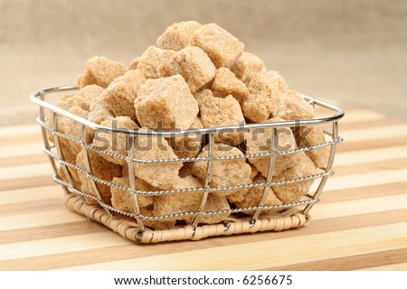 Heap of not refined brown reed sugar in a steel basket