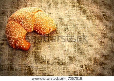 Croissant with sesame on a sacking background