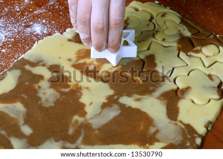 Spotty dough and star shape in hand, food background