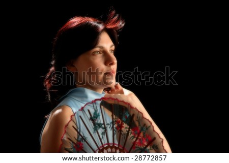 Young woman with spanish fan, isolated on black