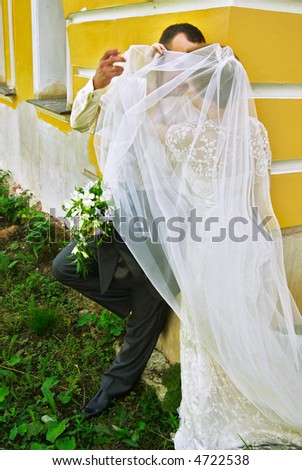 The groom and the bride are covered by a veil