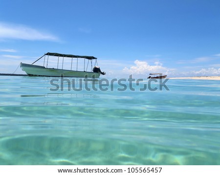 Water surface ripples with a boat anchored and sandy beach, Caribbean sea, Zapatilla island, Panama