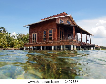 Tropical home on stilts over water of the Caribbean sea