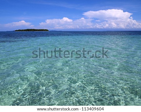 Turquoise water in the Caribbean sea with a tropical island at the horizon, Panama