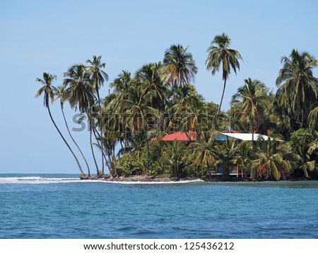 Waterfront house surrounded by coconut trees on a tropical island of the Caribbean sea, Panama, Central America