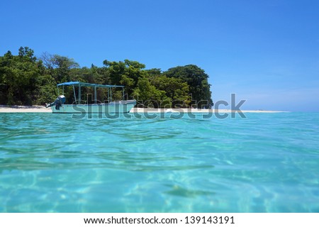 Tropical island beach with a boat in turquoise water, Caribbean sea, Panama