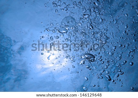 Air bubbles rising to water surface with sunlight, natural scene in the Caribbean sea