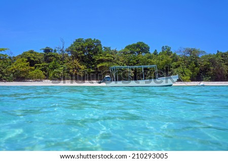 Tropical beach coastline with a boat, taken from water surface, Caribbean sea, Panama