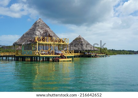 tropical eco resort over water with thatched roof made of dried palm leaves, Caribbean sea, Bocas del Toro, Panama