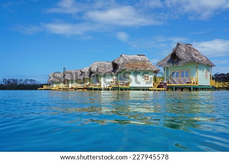 Tropical eco resort with thatched overwater bungalows, Caribbean sea, Bocas del Toro, Panama, Central America