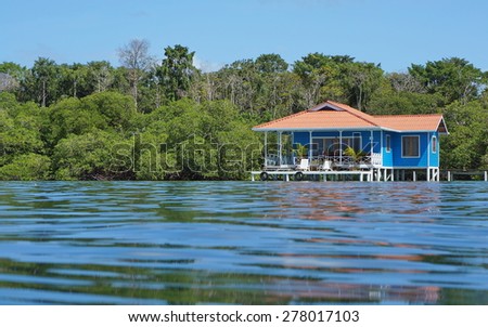 Overwater bungalow with vegetation in background viewed from sea surface, Caribbean, Panama