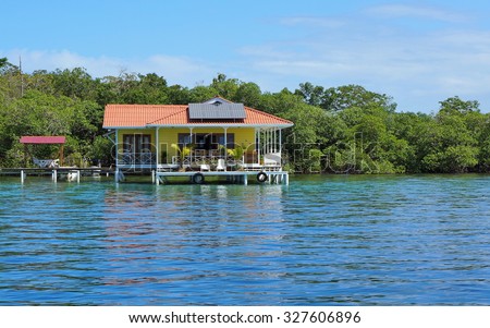 Off grid house over the sea with solar panels on the roof, Caribbean, Panama