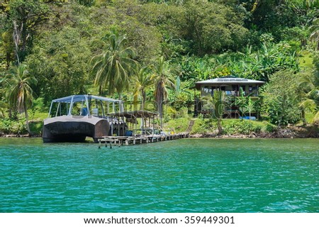 Tropical shore with an off-grid house and strange boat at dock on an island of the Caribbean coast of Panama, Bocas del Toro, Central America