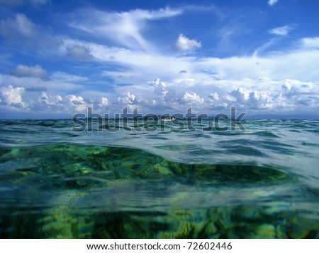 Water surface with a cargo ship and cloudy blue sky at the horizon, Caribbean sea, Panama
