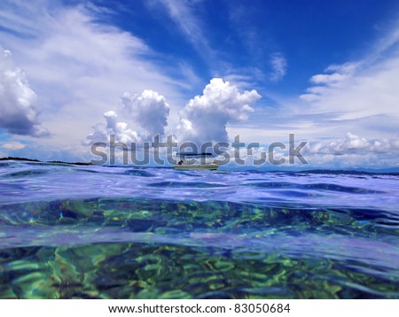 Sea surface with boat and cloudy blue sky on the horizon, Caribbean sea, Panama