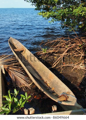 Amerindian dugout canoe out of water with the Caribbean sea in background, Bocas del Toro, Panama