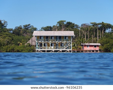 Tropical coast with hotel and a small house over water, Caribbean sea, Bocas del Toro, Panama
