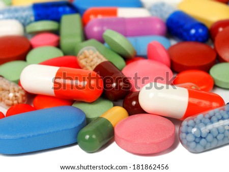 Macro of pills and capsules on white background, focus on nearest ones.