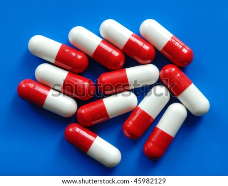 Macro of red and white capsules on blue background