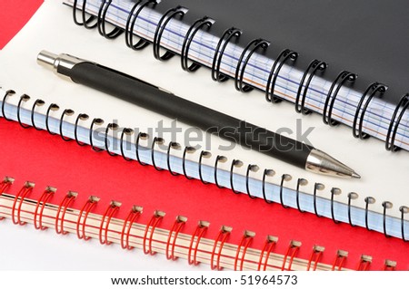 Spiral notepads and ball pen on white background