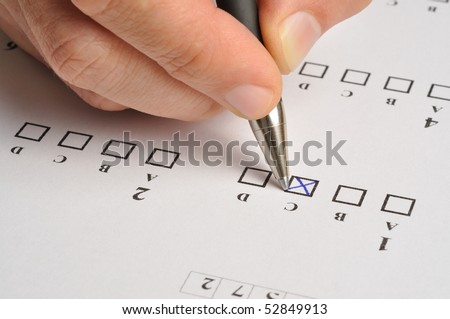 Macro of someone\'s hand filling exam answers form