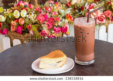 Cake and cocoa ice on wood table,flower background