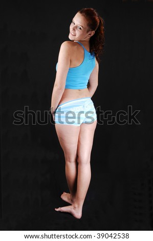 stock photo A young girl in workout pants and top standing in the studio 