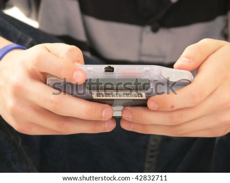 A young boy is playing with his play station, an close-up picture of his hands.