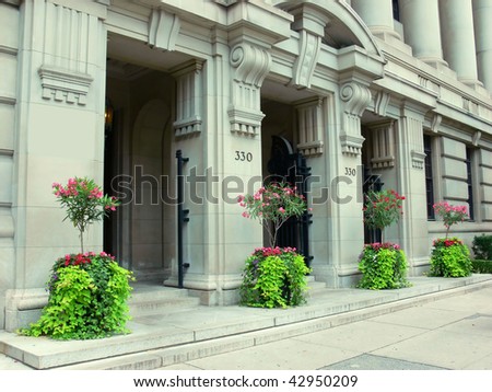 An old historic bank building in excelled conditions with four flowerpot on frond of the building.