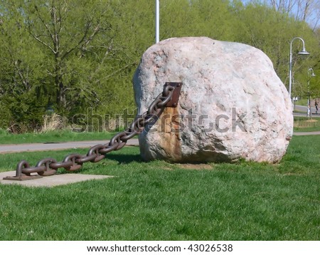A big stone on an heavy chain in the park at Hamilton harbor.