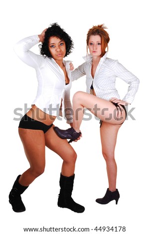 Two young woman in bikini and white blouse and black boots standing in a studio for white background