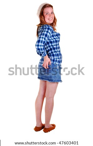 A beautiful Caucasian woman in a short denim skirt and high heels standing in the studio and holding her butt, for white background.