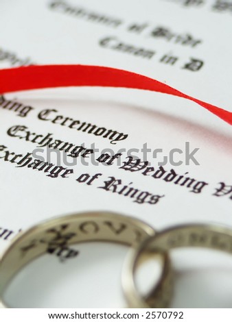 focus on wedding program words, rings out of focus
