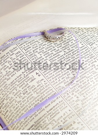 diamond ring with trailing ribbons and ivory fabric with the word of love
