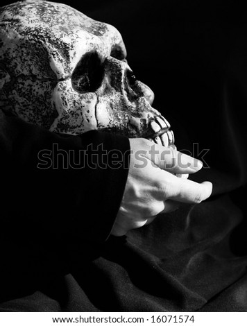 For Halloween - a hand holding a skull against a black background