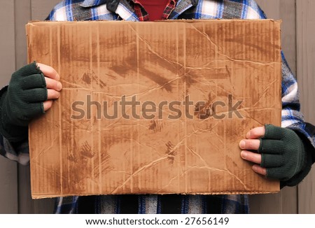 homeless man holding up blank cardboard sign